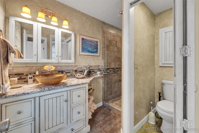 29898 S 566th Rd Unit 411, Afton, OK 74331 - full bath with vanity, toilet, tiled shower, wood finished floors, and decorative backsplash