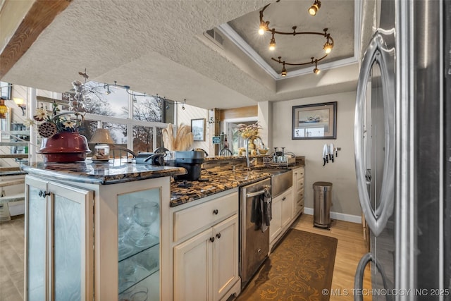 29898 S 566th Rd Unit 411, Afton, OK 74331 - kitchen featuring stainless steel appliances, a peninsula, a sink, a tray ceiling, and dark stone countertops