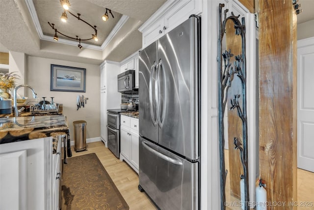 29898 S 566th Rd Unit 411, Afton, OK 74331 - kitchen featuring stainless steel appliances, crown molding, a tray ceiling, light wood-type flooring, and white cabinets