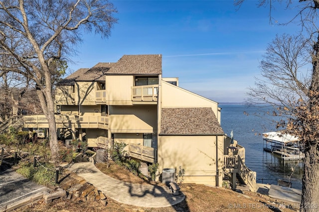 29898 S 566th Rd Unit 411, Afton, OK 74331 - view of property exterior featuring a balcony, a water view, and a shingled roof