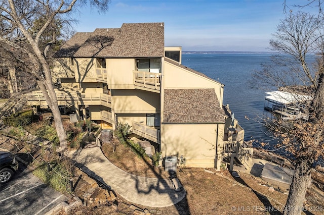 29898 S 566th Rd Unit 411, Afton, OK 74331 - view of side of home featuring a water view, a balcony, and a shingled roof