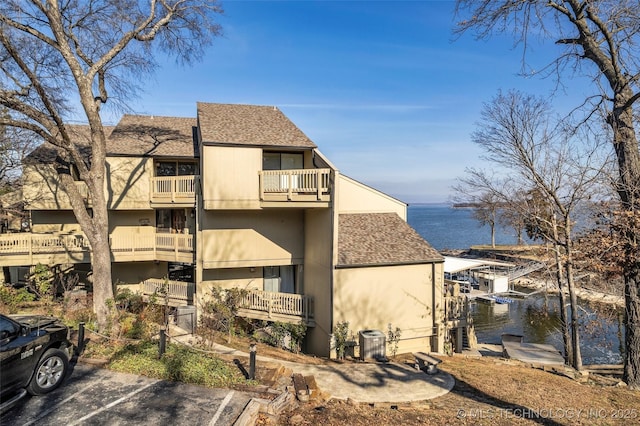 29898 S 566th Rd Unit 411, Afton, OK 74331 - back of property featuring a balcony, a shingled roof, uncovered parking, a water view, and central AC