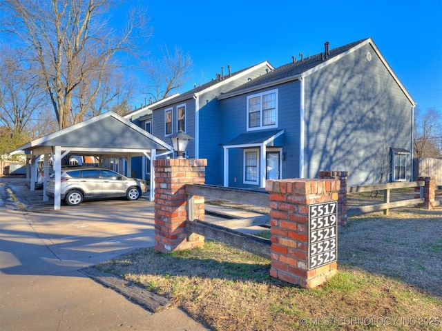 view of front facade with driveway and fence