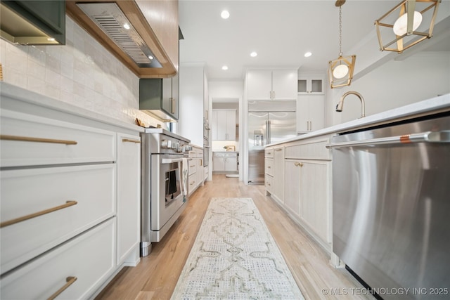 1641 E 32nd St, Tulsa, OK 74105 - kitchen with appliances with stainless steel finishes, custom exhaust hood, tasteful backsplash, light countertops, and recessed lighting