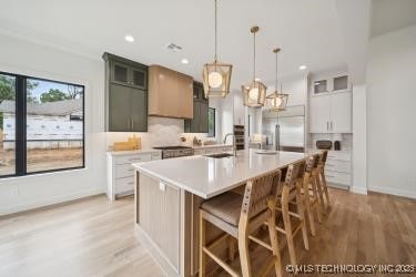 1641 E 32nd St, Tulsa, OK 74105 - kitchen featuring stainless steel refrigerator with ice dispenser, light countertops, light wood finished floors, a large island with sink, and recessed lighting