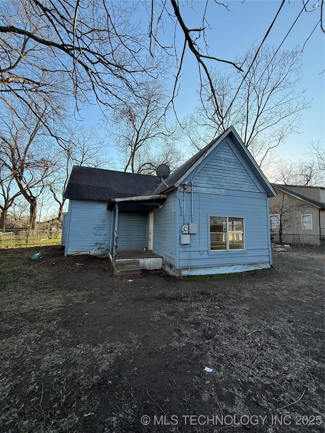 rear view of property featuring fence