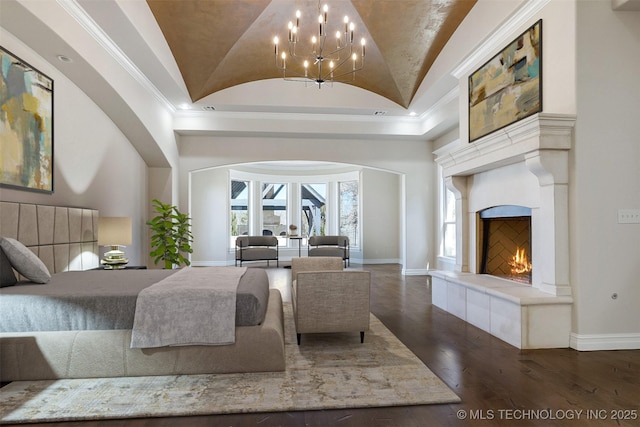 bedroom featuring lofted ceiling, baseboards, and wood finished floors