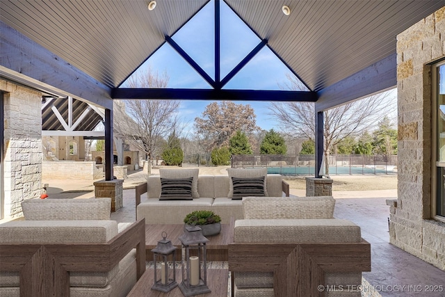 view of patio with an outdoor living space with a fireplace and fence