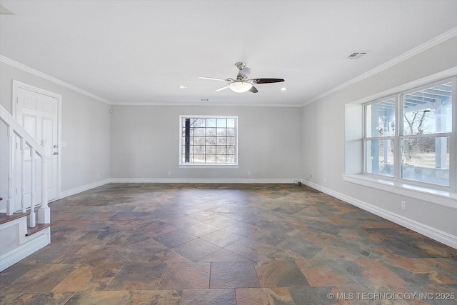 spare room with visible vents, ornamental molding, stone finish floor, ceiling fan, and baseboards