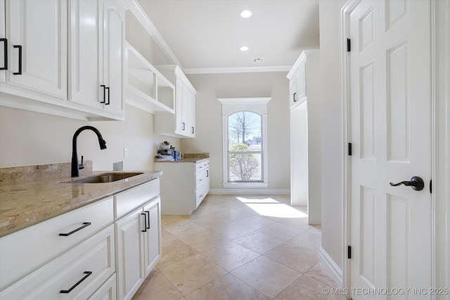 kitchen featuring crown molding, white cabinetry, open shelves, and a sink