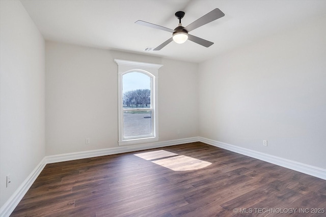 empty room featuring ceiling fan, dark wood-style flooring, visible vents, and baseboards