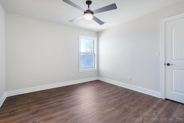 spare room with dark wood-style floors, ceiling fan, and baseboards