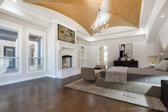 bedroom featuring a notable chandelier, lofted ceiling, a high end fireplace, wood finished floors, and baseboards