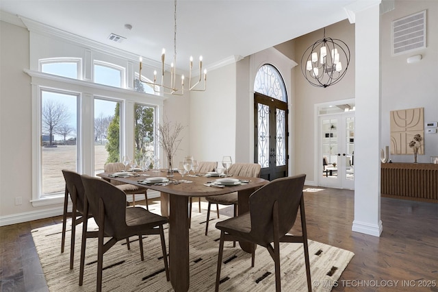 dining space with visible vents, an inviting chandelier, crown molding, french doors, and a healthy amount of sunlight