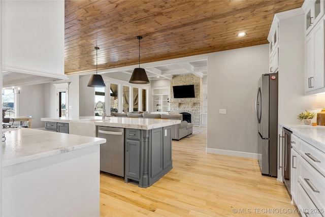 kitchen with white cabinets, appliances with stainless steel finishes, glass insert cabinets, open floor plan, and gray cabinets