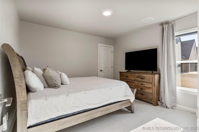 bedroom with baseboards, visible vents, and light colored carpet