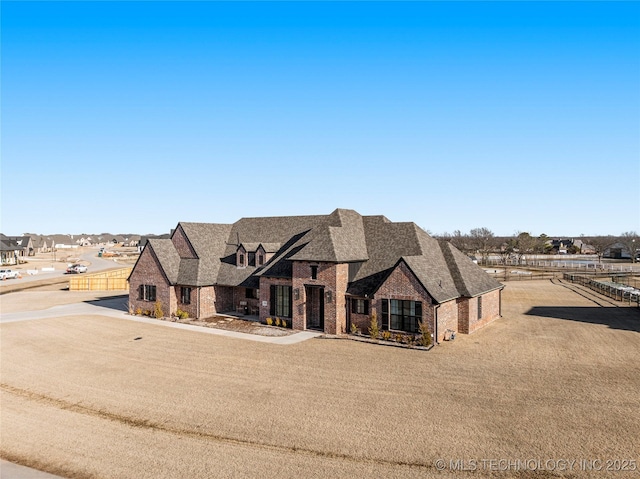 view of front of property with a shingled roof, a residential view, fence, and brick siding