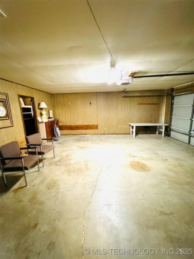 garage with wood walls and a garage door opener