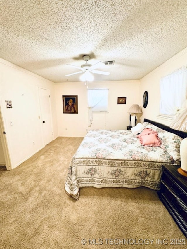 carpeted bedroom with ceiling fan, visible vents, and a textured ceiling