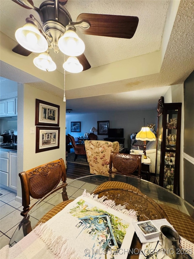 bedroom with a textured ceiling, ceiling fan, light tile patterned flooring, and a sink