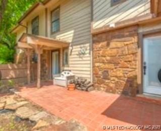 6371 S 80th E Ave Unit 6H, Tulsa, OK 74133 - back of property with stone siding and a patio