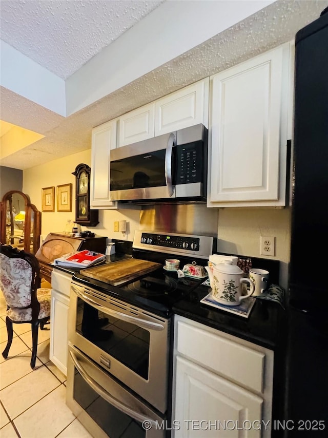 kitchen with stainless steel appliances, white cabinets, and light tile patterned floors