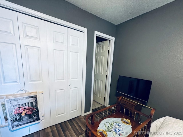 bedroom featuring wood finished floors, a textured ceiling, and a closet
