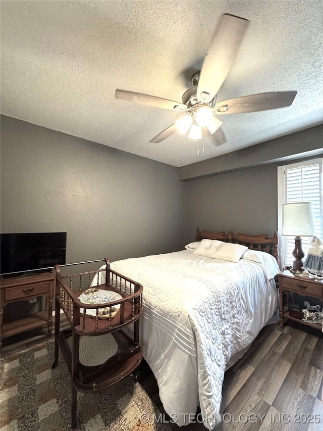bedroom featuring ceiling fan, wood finished floors, and a textured ceiling