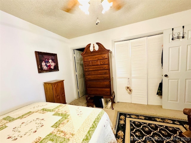 carpeted bedroom featuring a textured ceiling, a closet, and ceiling fan