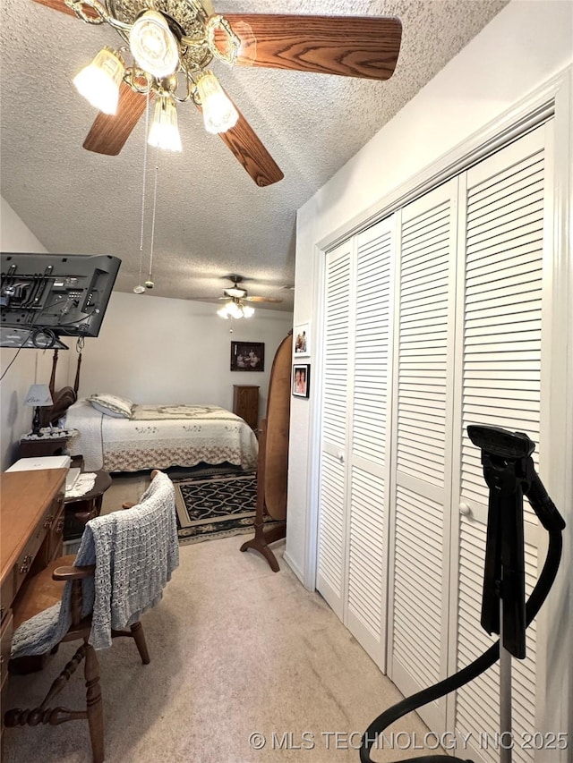 bedroom with a closet, ceiling fan, a textured ceiling, and light carpet