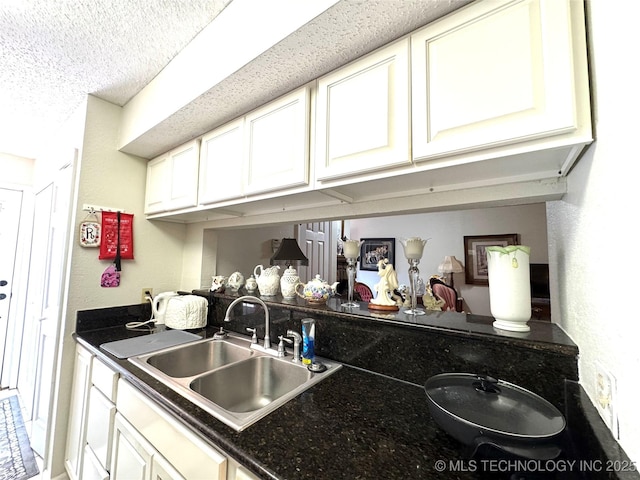 6371 S 80th E Ave Unit 6H, Tulsa, OK 74133 - kitchen featuring dark countertops, white cabinets, and a textured ceiling