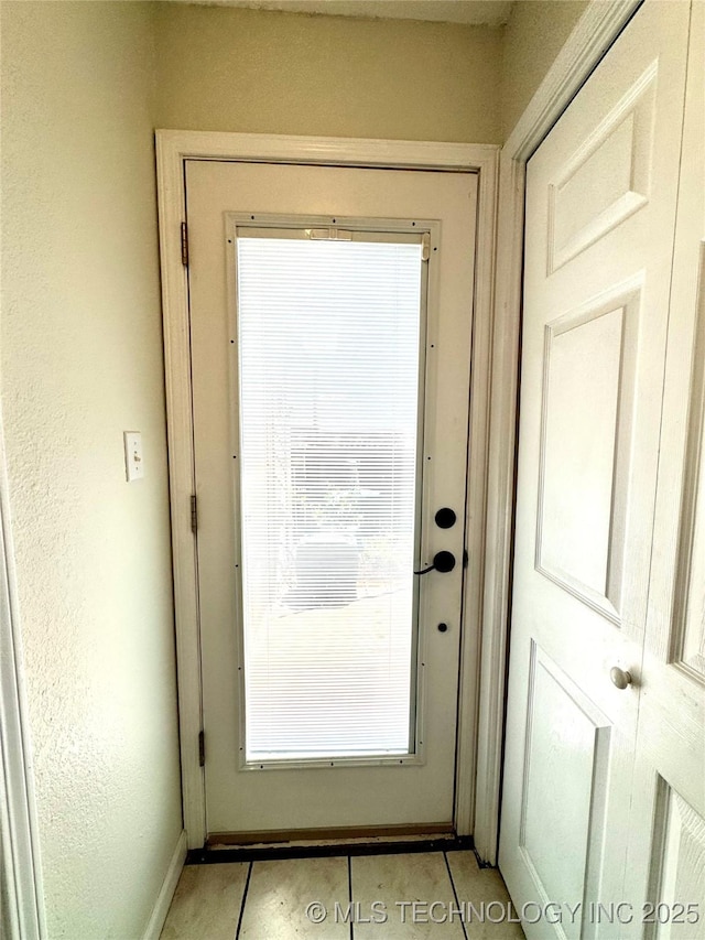 entryway featuring baseboards and light tile patterned floors