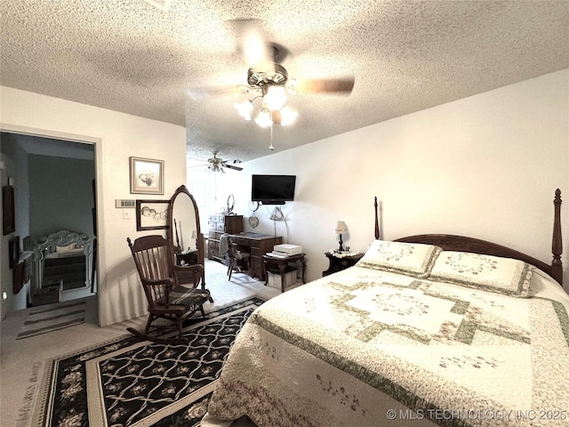 carpeted bedroom with ceiling fan and a textured ceiling