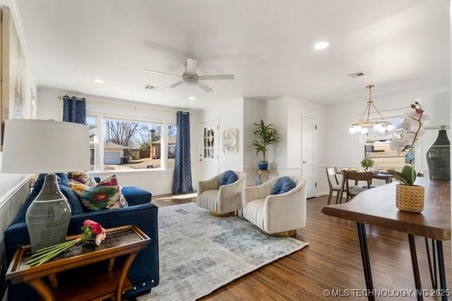 living area featuring ceiling fan with notable chandelier, wood finished floors, visible vents, and recessed lighting