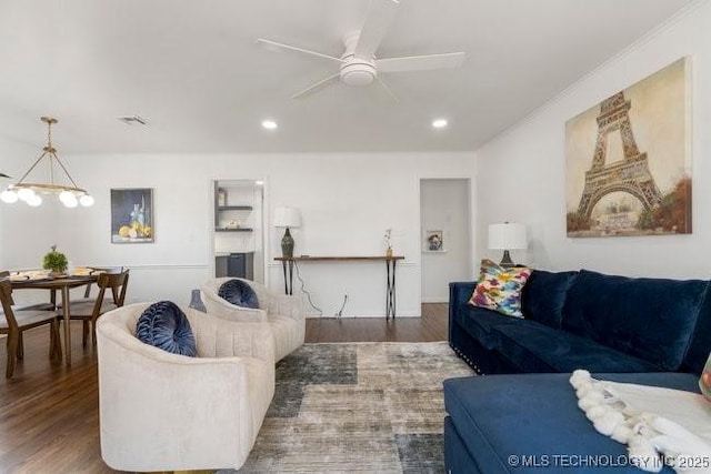 living room with recessed lighting, wood finished floors, and ceiling fan with notable chandelier