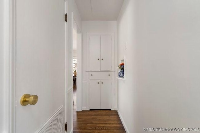 corridor with dark wood-style floors and baseboards