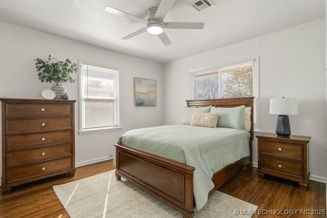 bedroom with wood finished floors, visible vents, baseboards, and multiple windows