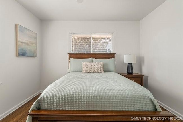 bedroom featuring baseboards and wood finished floors