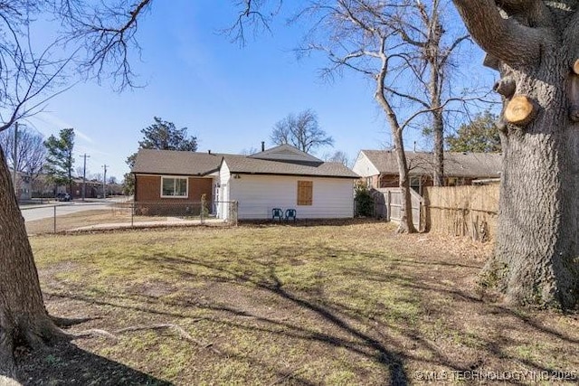 exterior space featuring a front lawn and fence