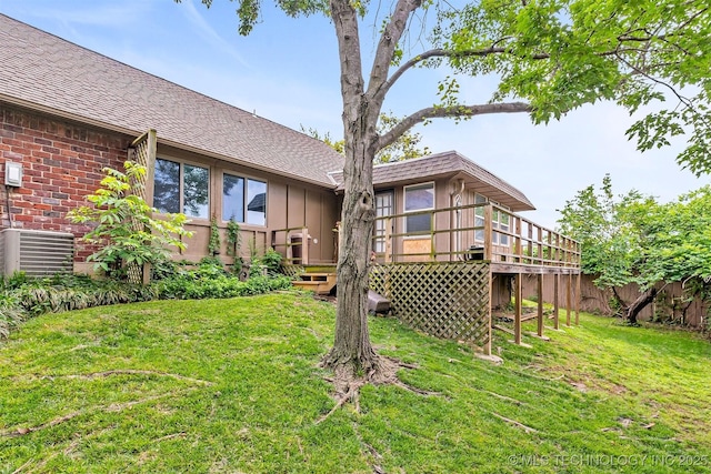 view of yard with central AC, a wooden deck, and fence