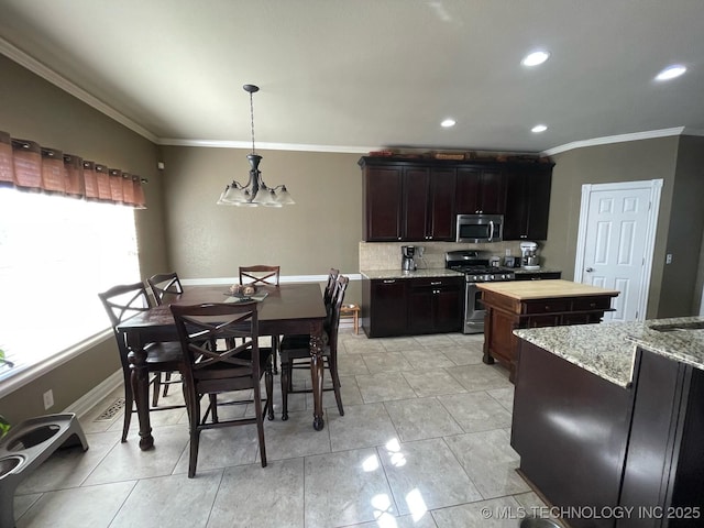 kitchen featuring ornamental molding, hanging light fixtures, stainless steel appliances, dark brown cabinets, and wooden counters