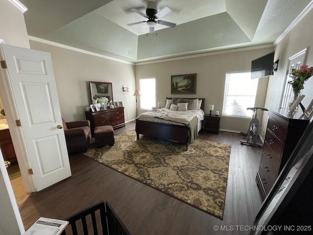 bedroom featuring baseboards, dark wood-style flooring, a tray ceiling, vaulted ceiling, and crown molding