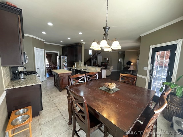 dining space featuring a chandelier, light tile patterned floors, recessed lighting, and crown molding