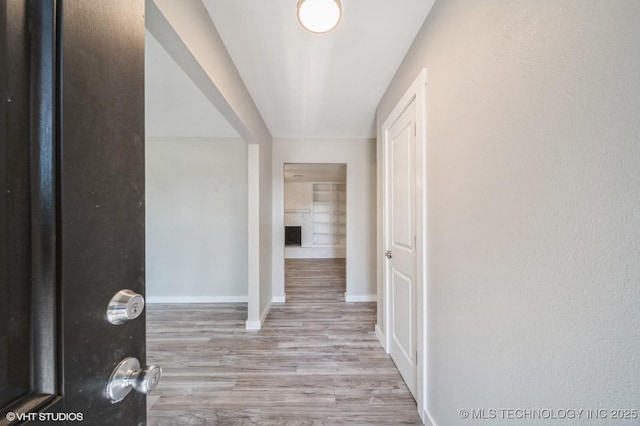 hall featuring baseboards and light wood-style floors