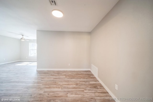 unfurnished room featuring baseboards, a ceiling fan, visible vents, and light wood-style floors