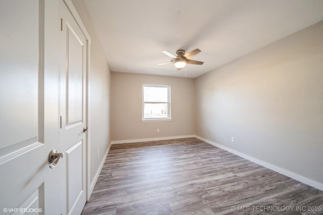 empty room with light wood-type flooring, ceiling fan, and baseboards