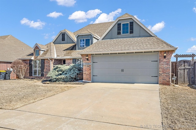 traditional home with a garage, driveway, brick siding, and roof with shingles