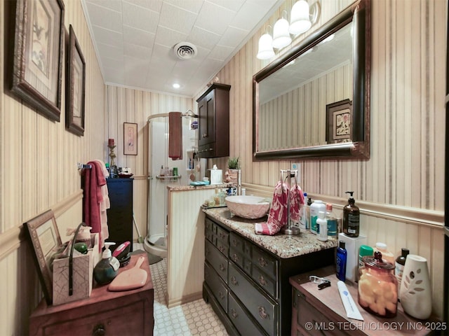 bathroom with a wainscoted wall, visible vents, and wallpapered walls