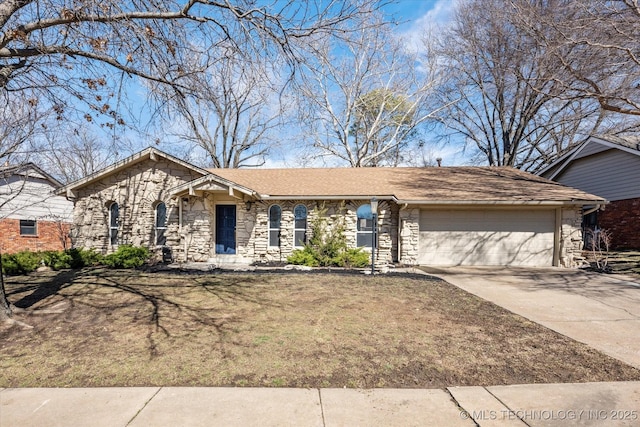 view of front of house featuring stone siding, driveway, and an attached garage