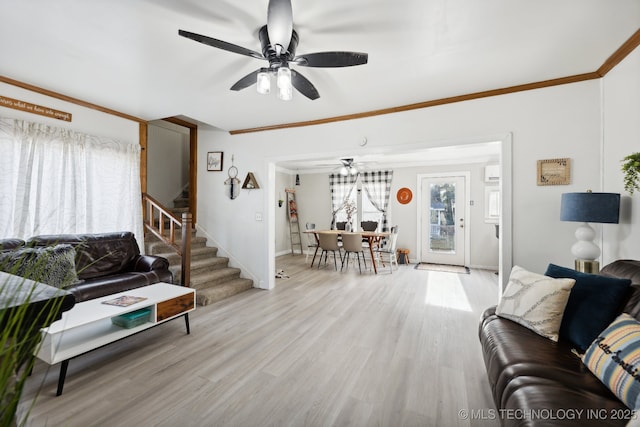 living area with baseboards, ceiling fan, stairs, crown molding, and light wood-type flooring